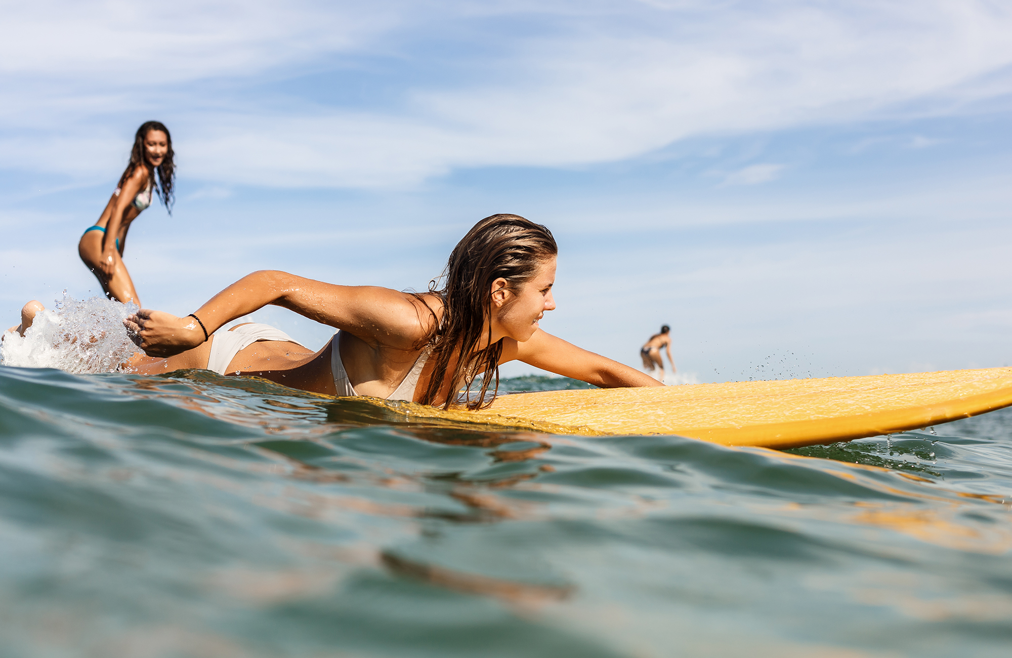 Två kvinnor surfar i Canggu