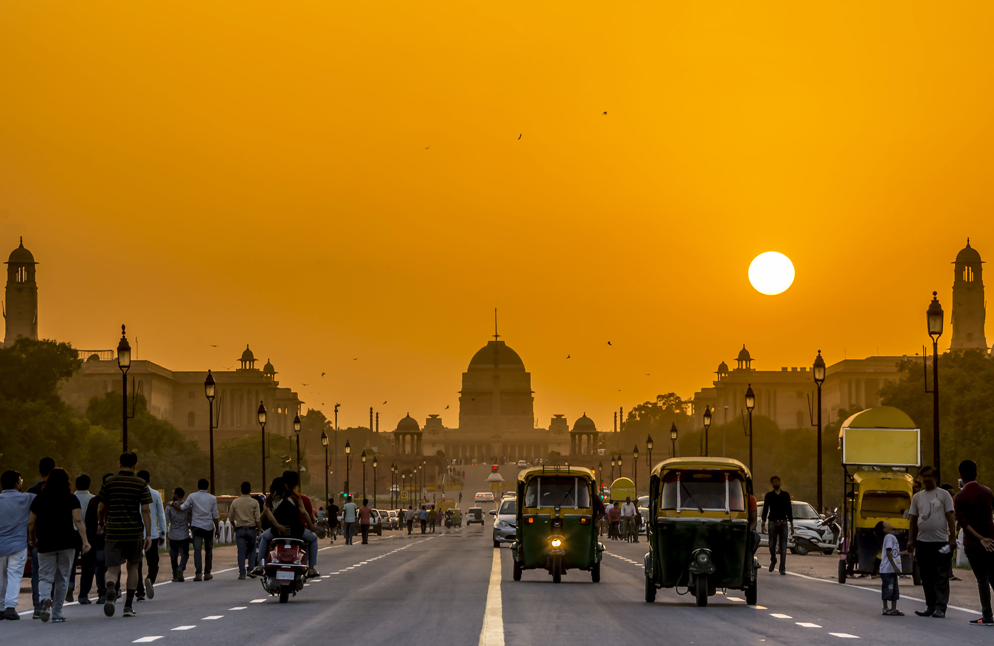 tuktuks och trafik på en stor gata i new delhi