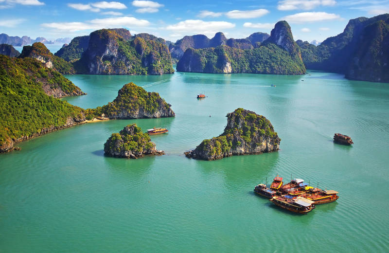 Limestone rocks and a couple of boats in the famous Ha Long Bay in Vietnam