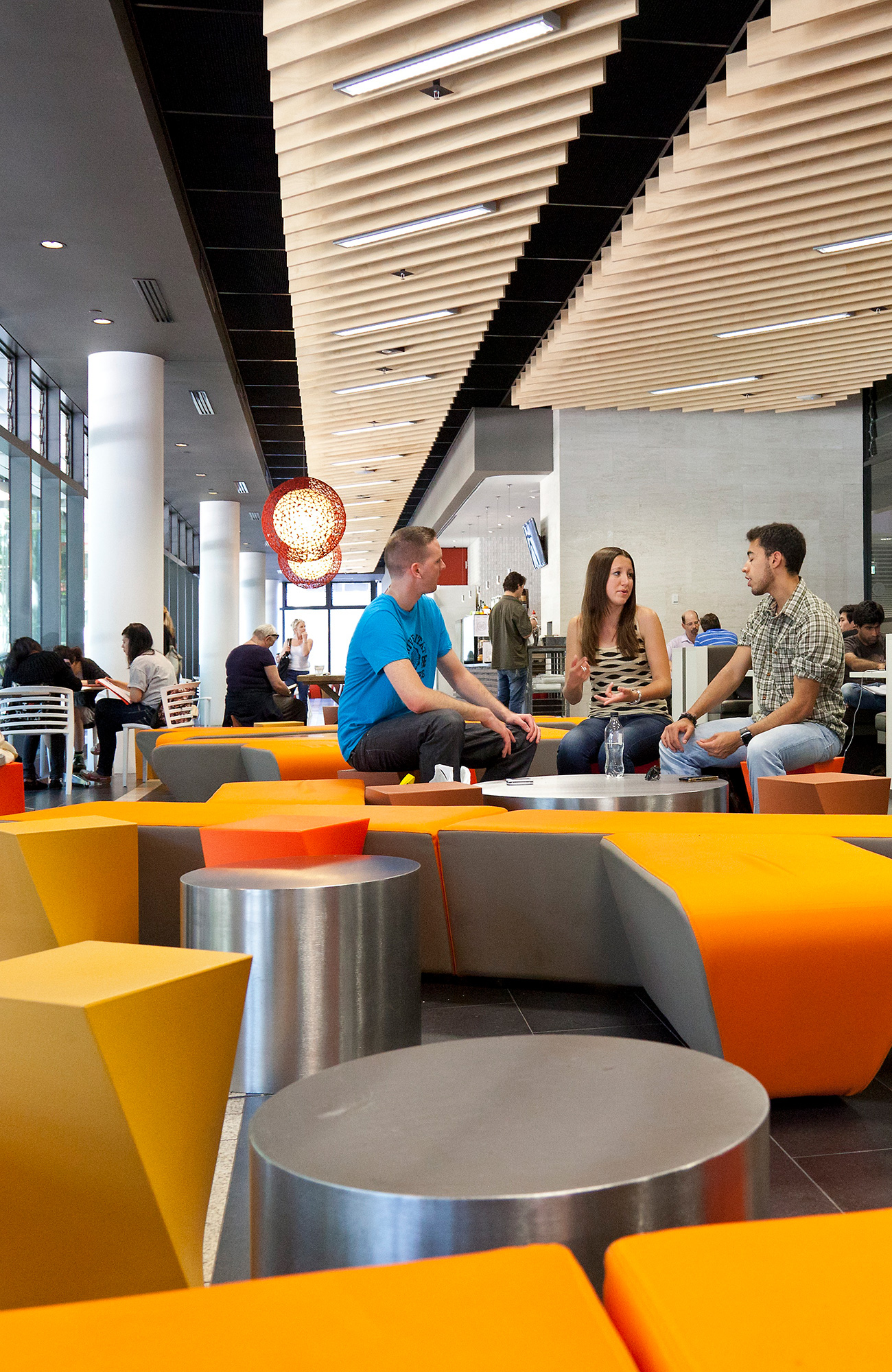 En kvinna och två män diskuteter inne på campus vid University of New South Wales (UNSW)