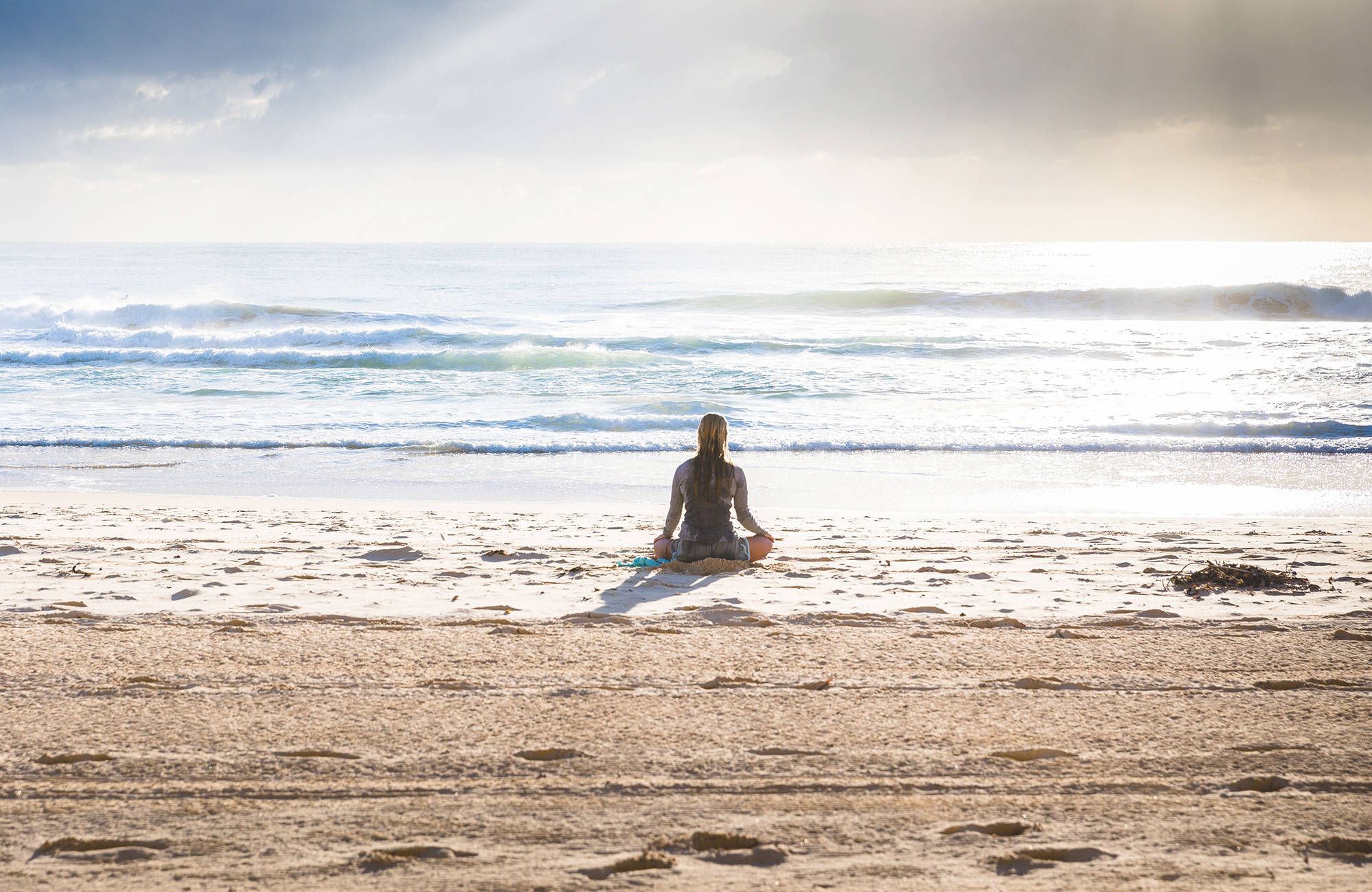 tjej tränar yoga på en strand