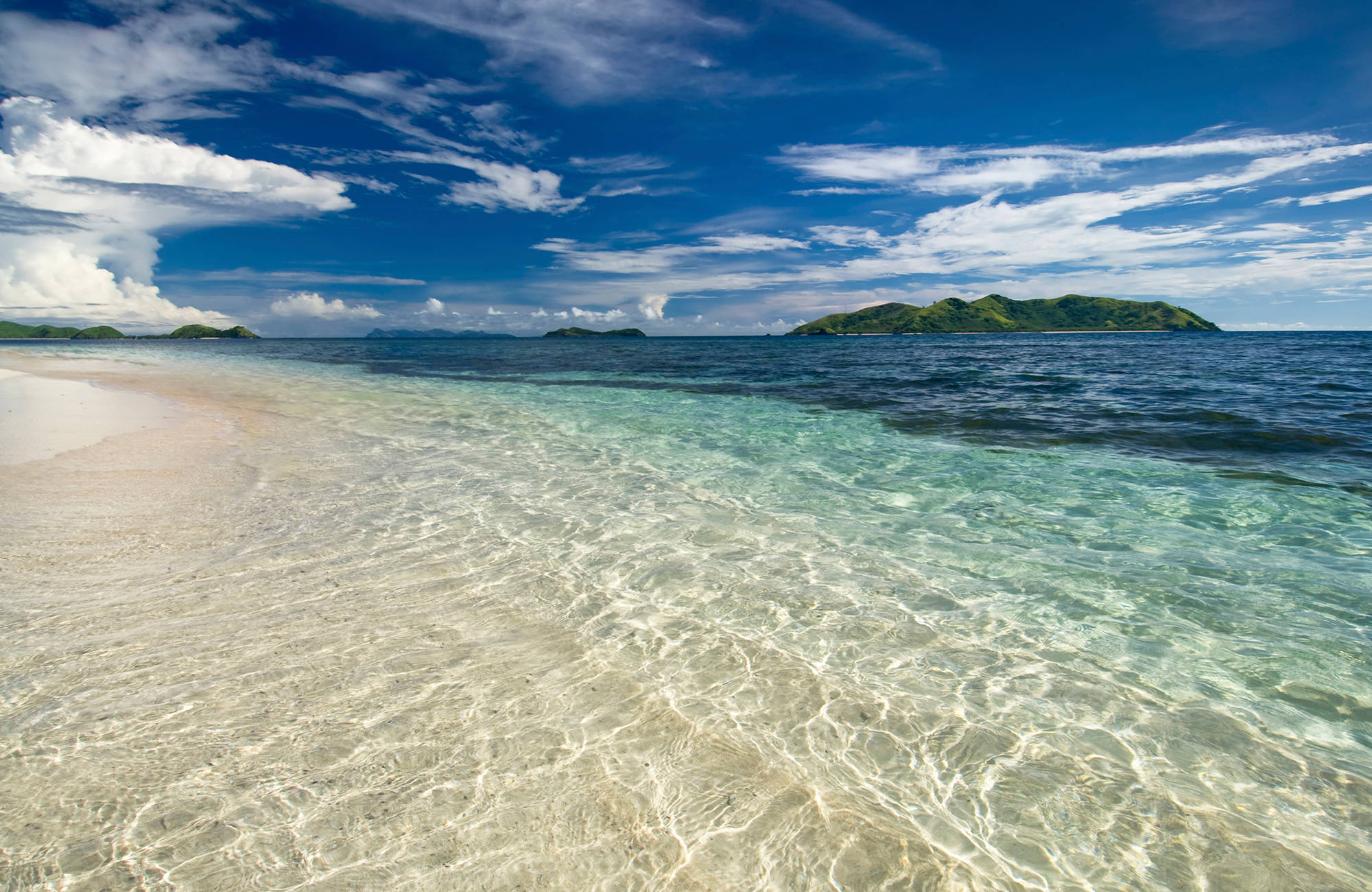 Kristallklart vatten utanför Fijis stränder.