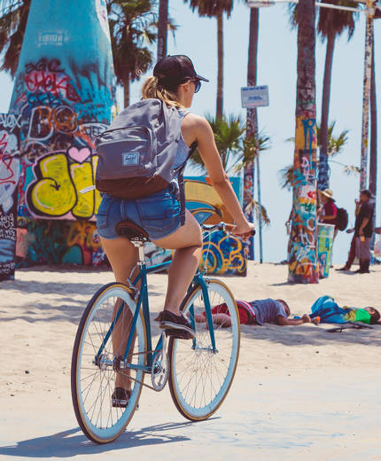 tjej provar på att cykla utomlands på en strand