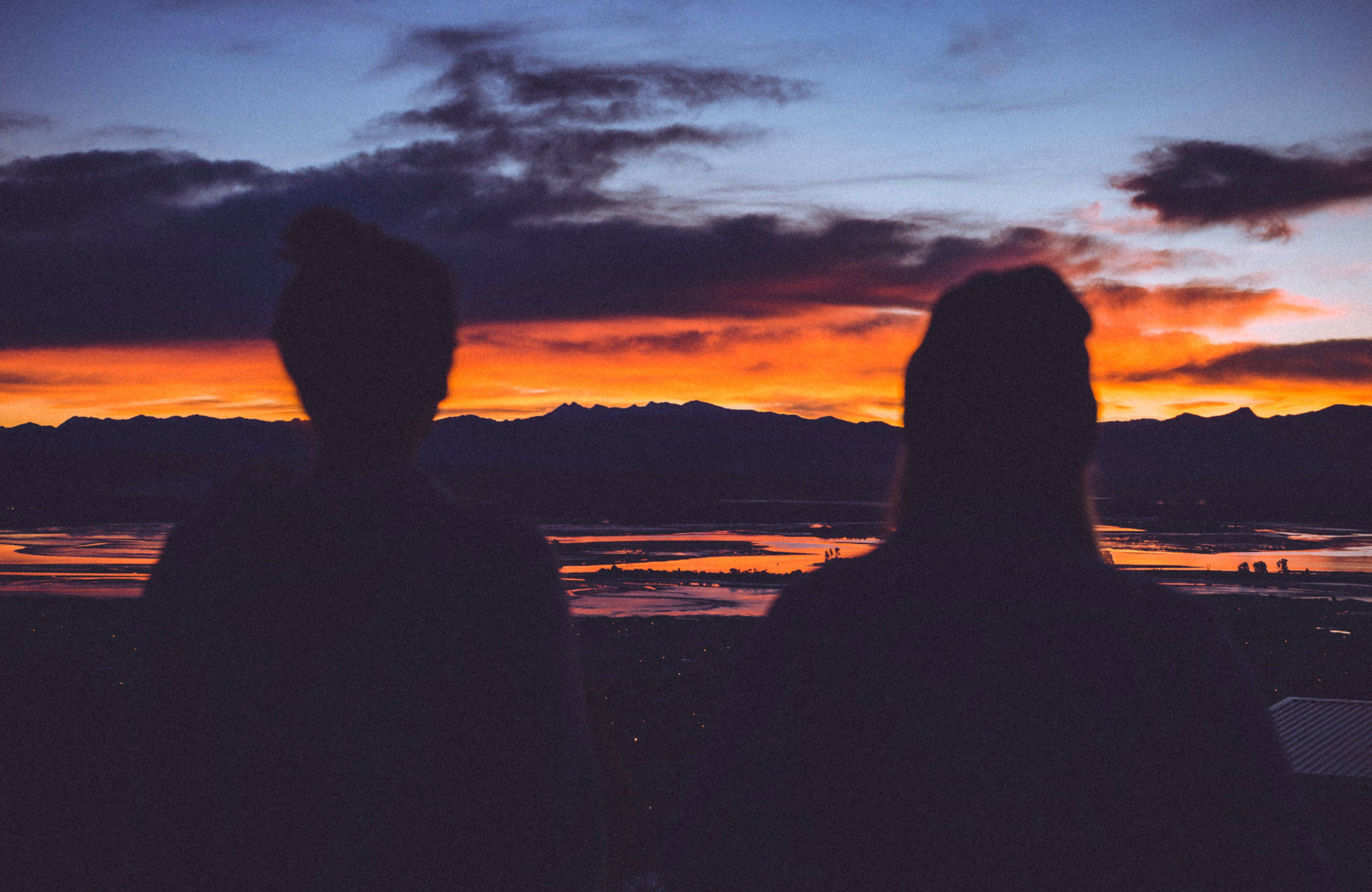 två tjejer ser solnedgången i nya zeeland