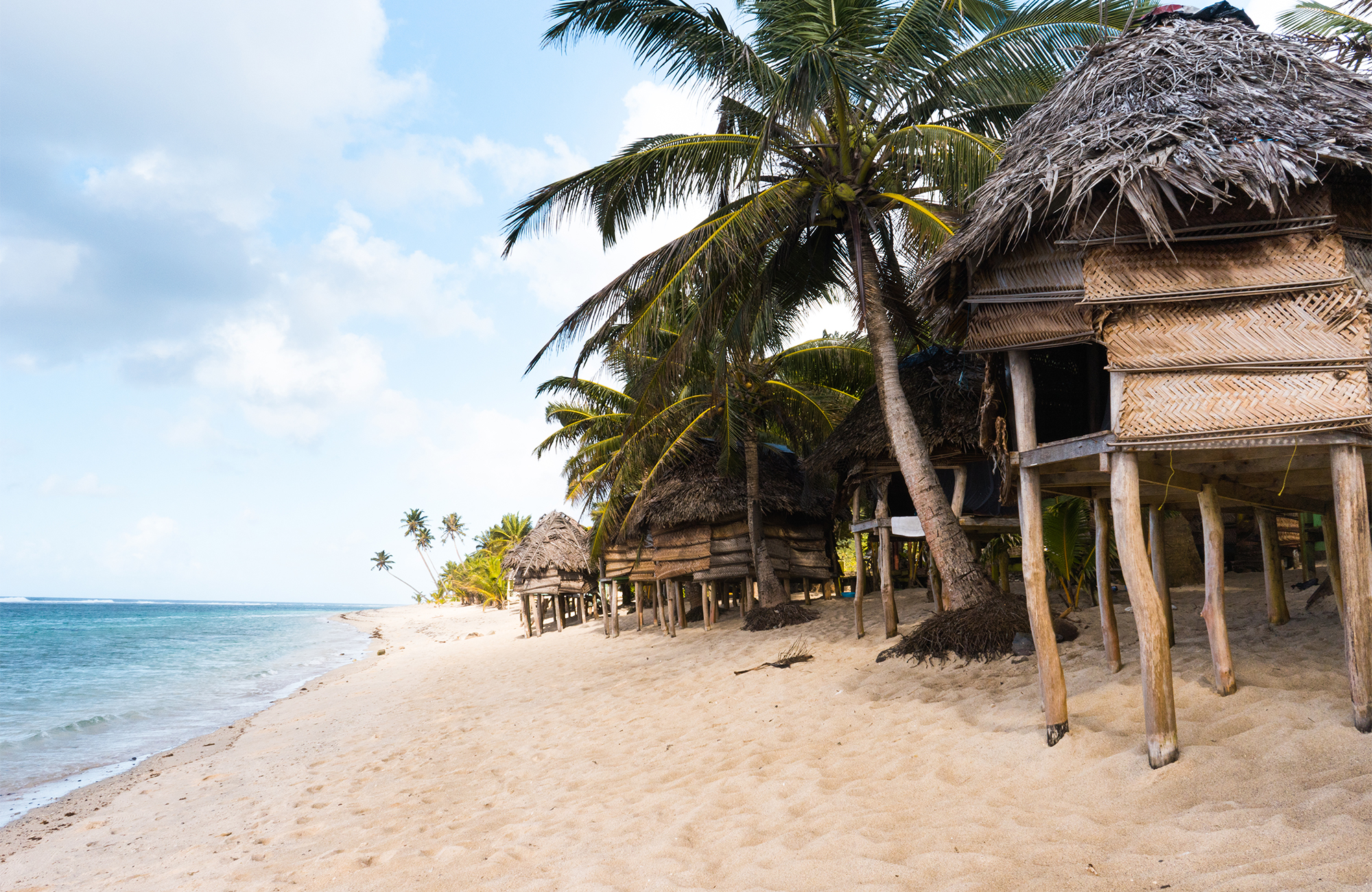 Bungalows på en strand i Samoa