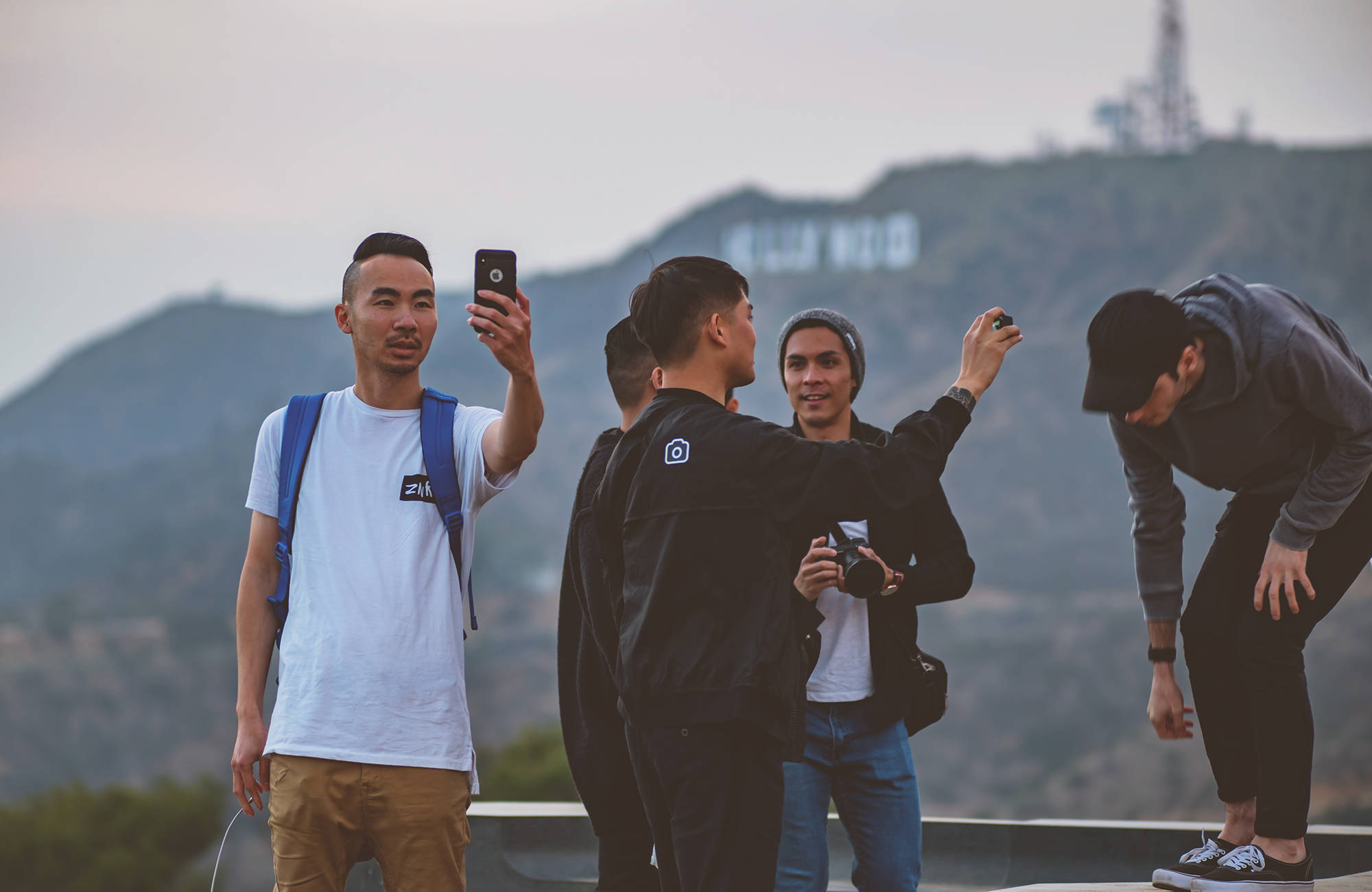 fem manliga studenter tar selfies vid hollywoodskylten, los angeles