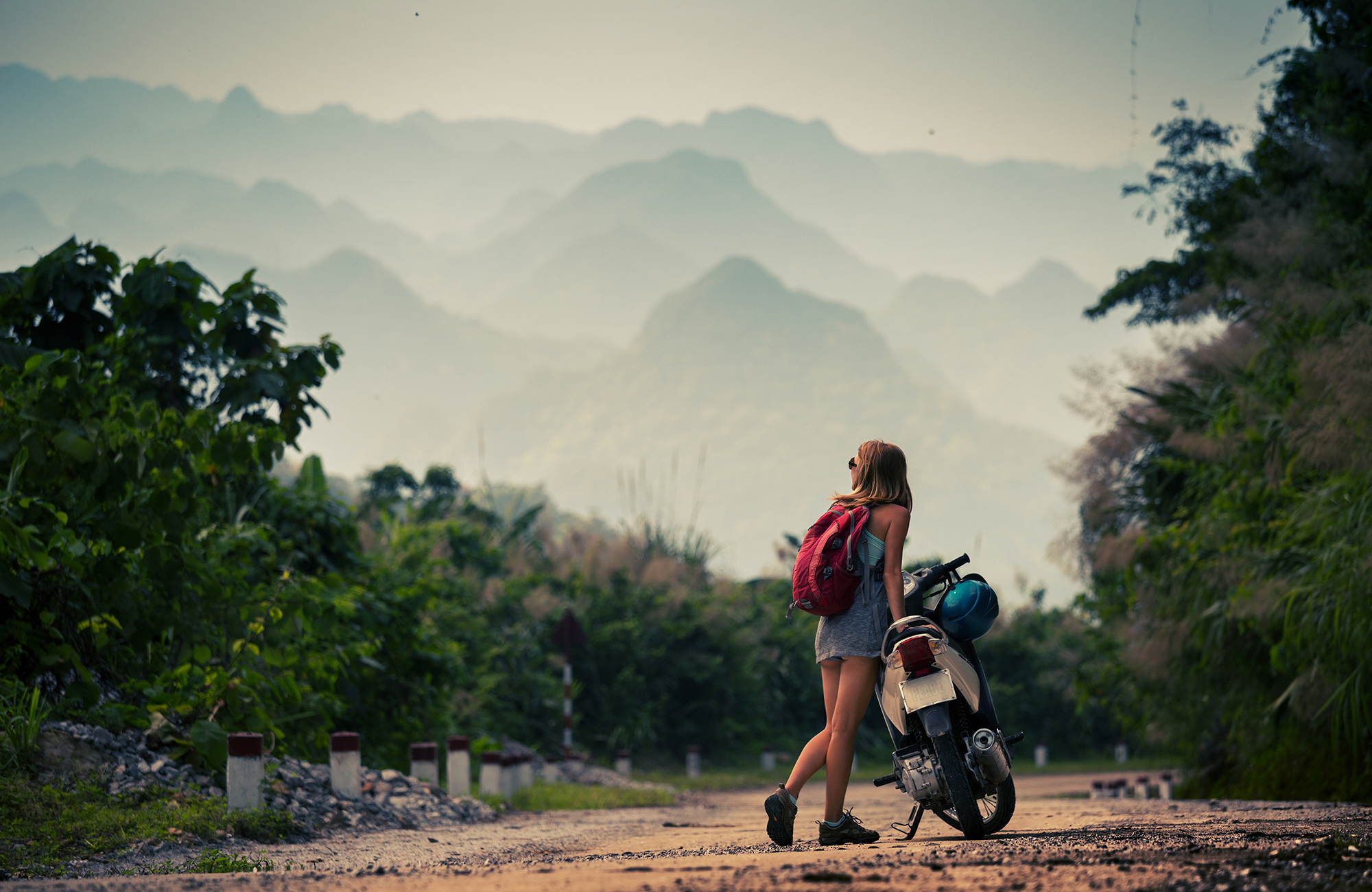 Kvinna med moped och ryggsäck backapckar i Asien under ett sabbatsår.