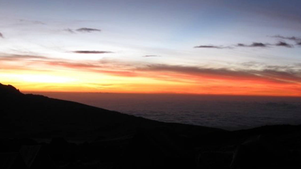 En vacker solnedgång över Kilimanjaro topp över molnen.