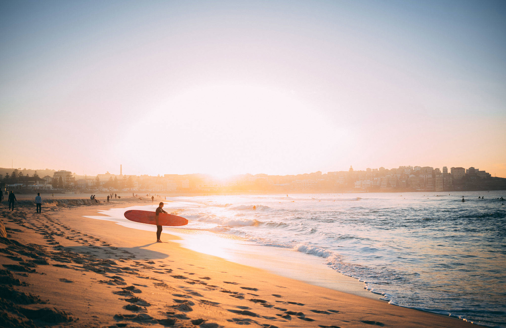 En surfkille i solnedgången i väntan på vågorna i Australien
