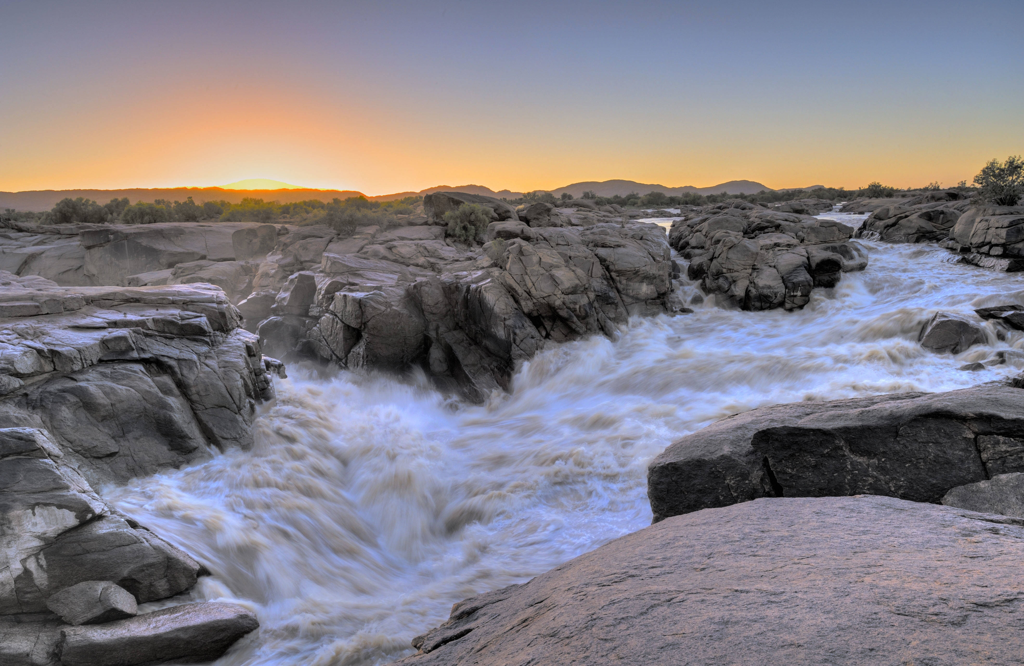 Forsande flod i solnedgång i Sydafrika.