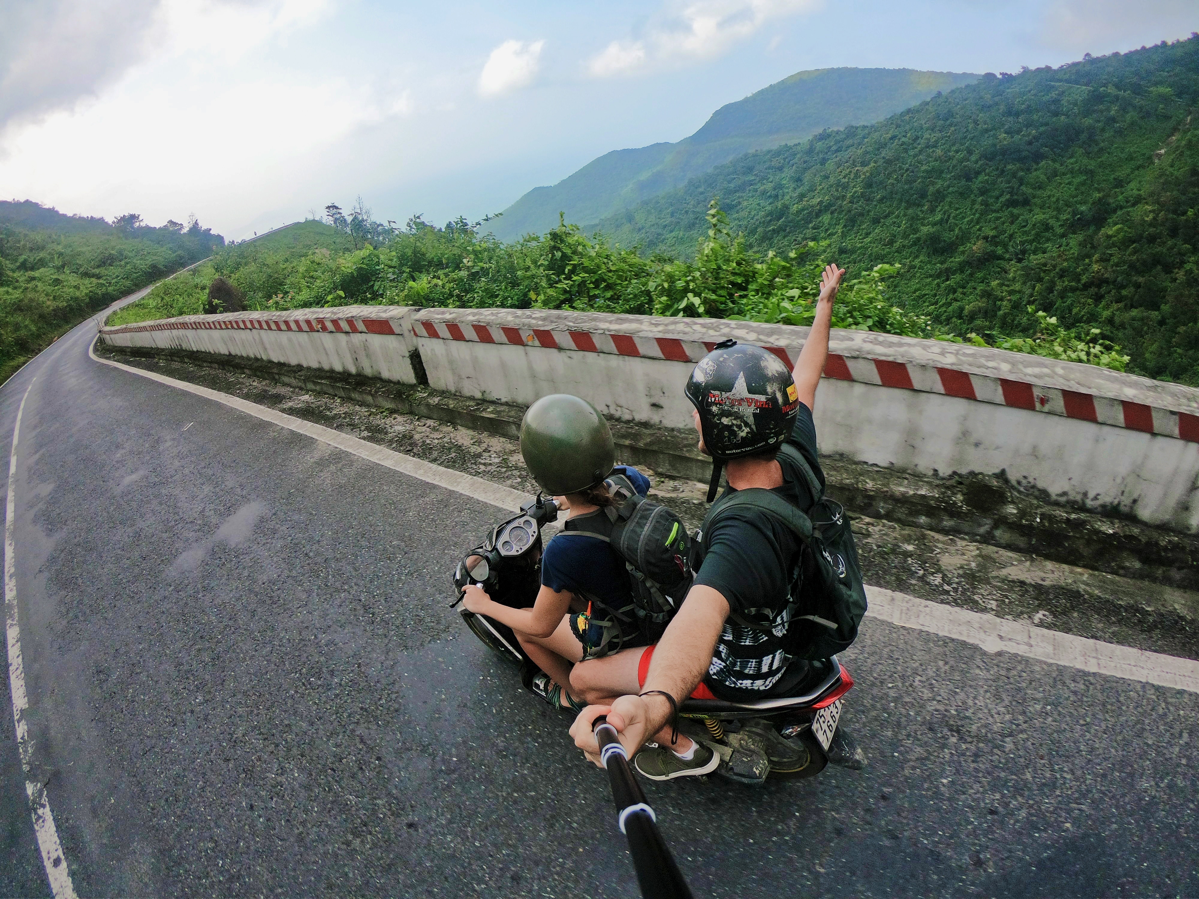 Två personer åker moped i Vietnam.