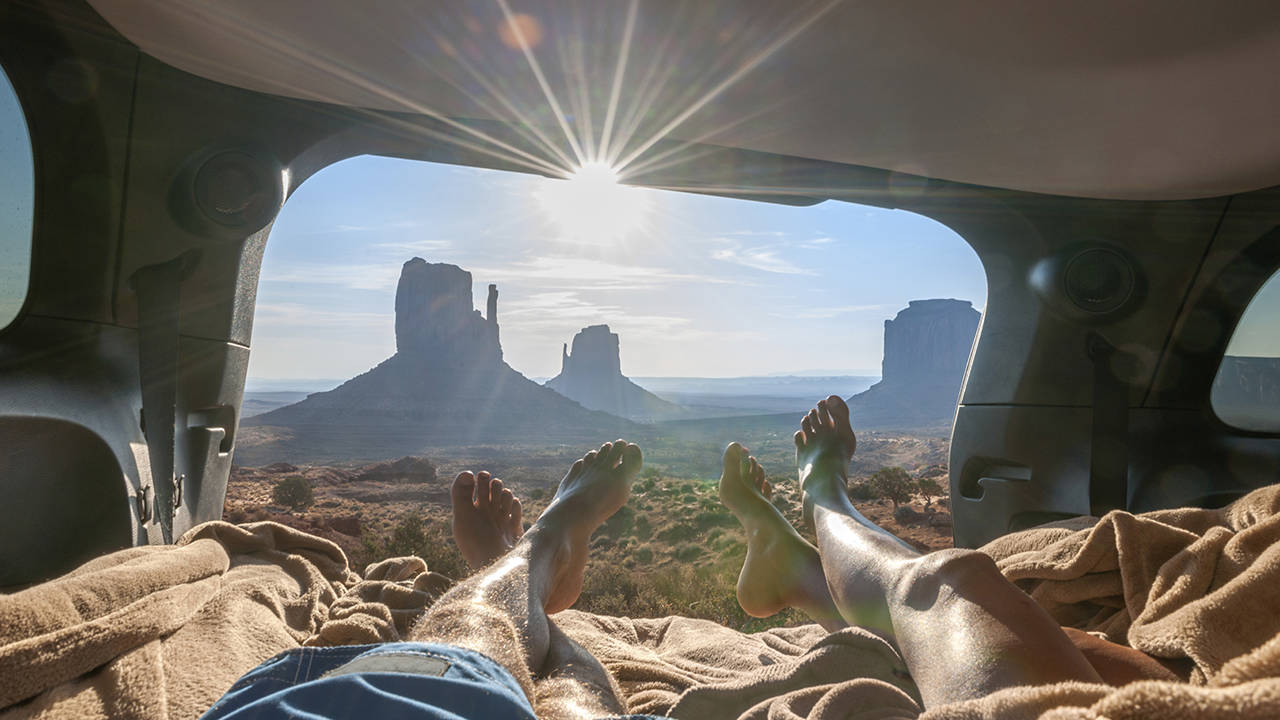 Ett par ligger barfota i en campervan i Grand Canyon under en resa i maj.