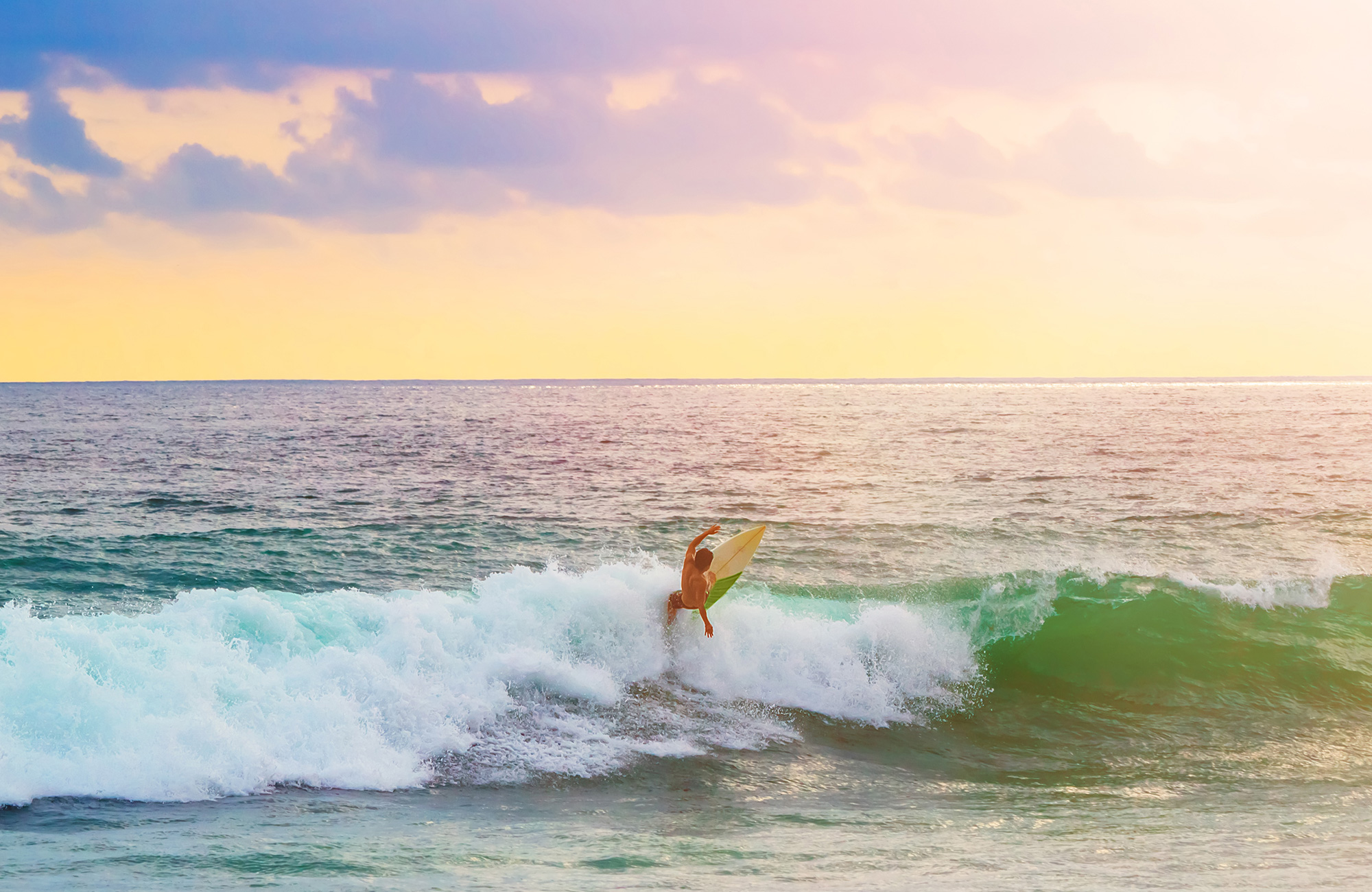 Kille som surfar i Peru i solnedgången