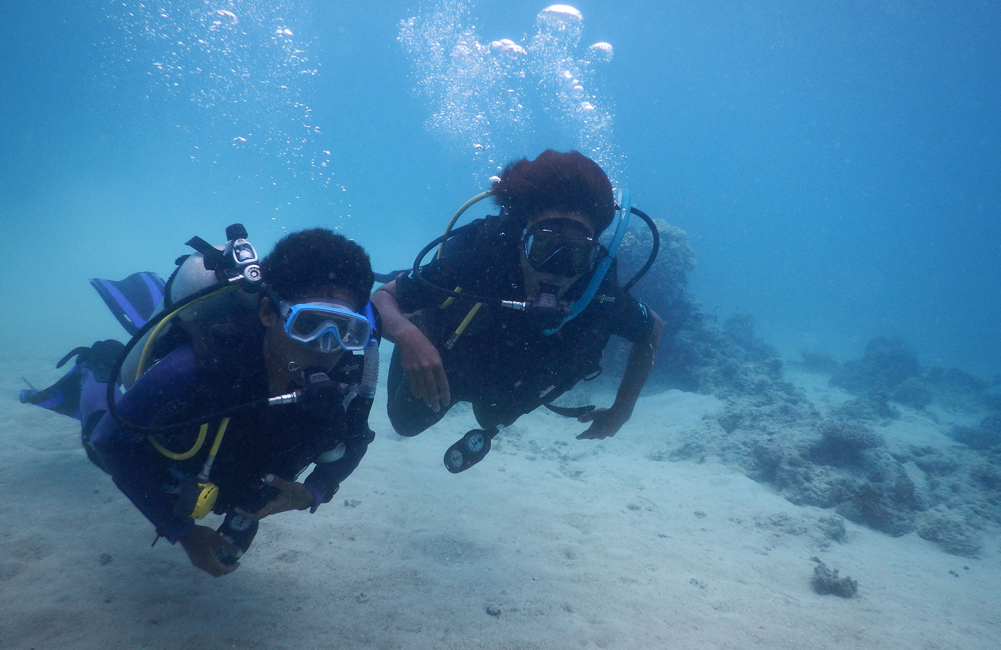 Två dykare under ytan som volontärarbetar vid havet