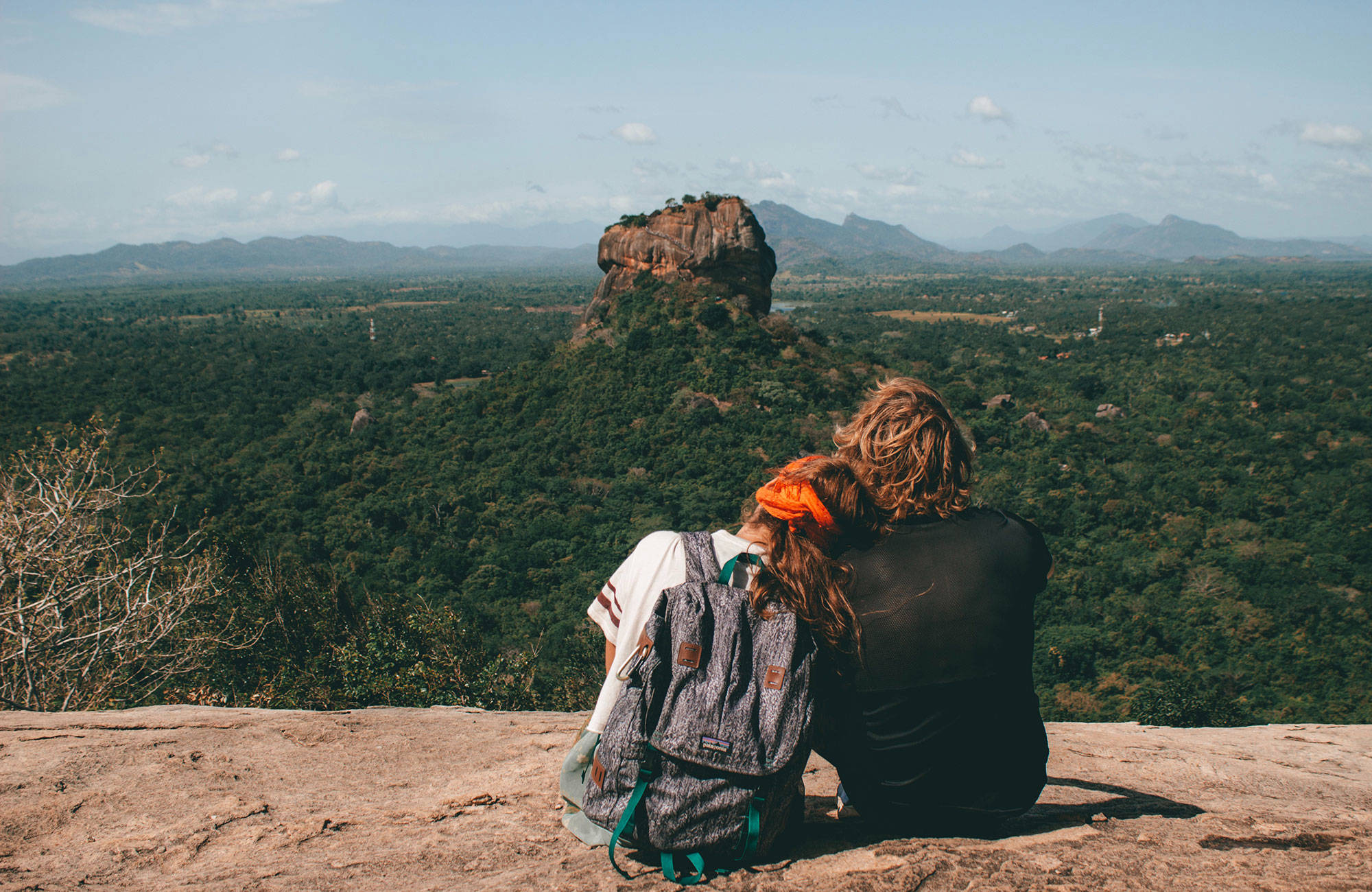 En mas och en kvinna kollar in utsikten över skogen under en rundresa i Sri Lanka.