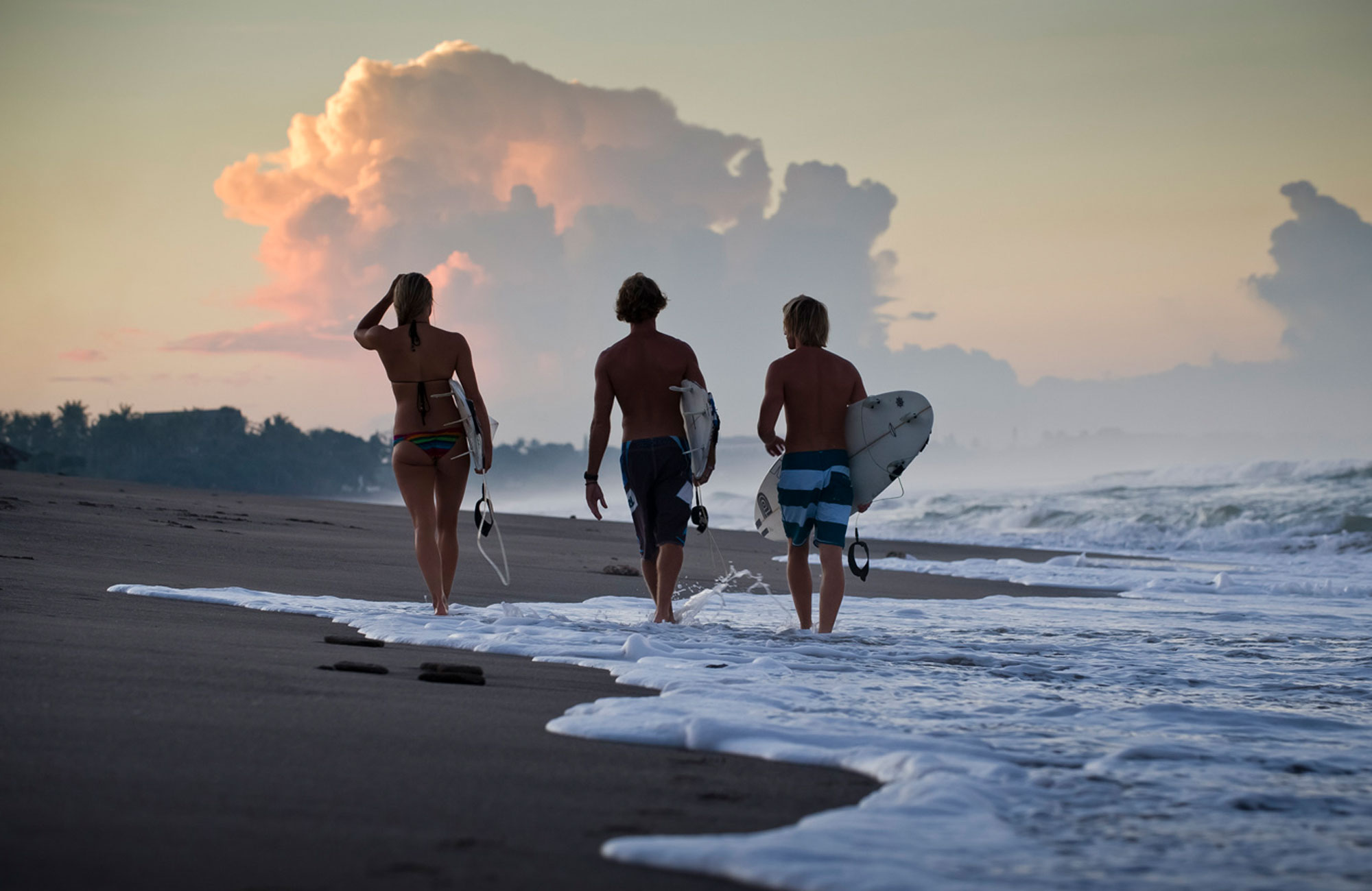 man som går i vattnet som är taggad på att surfa i indonesien