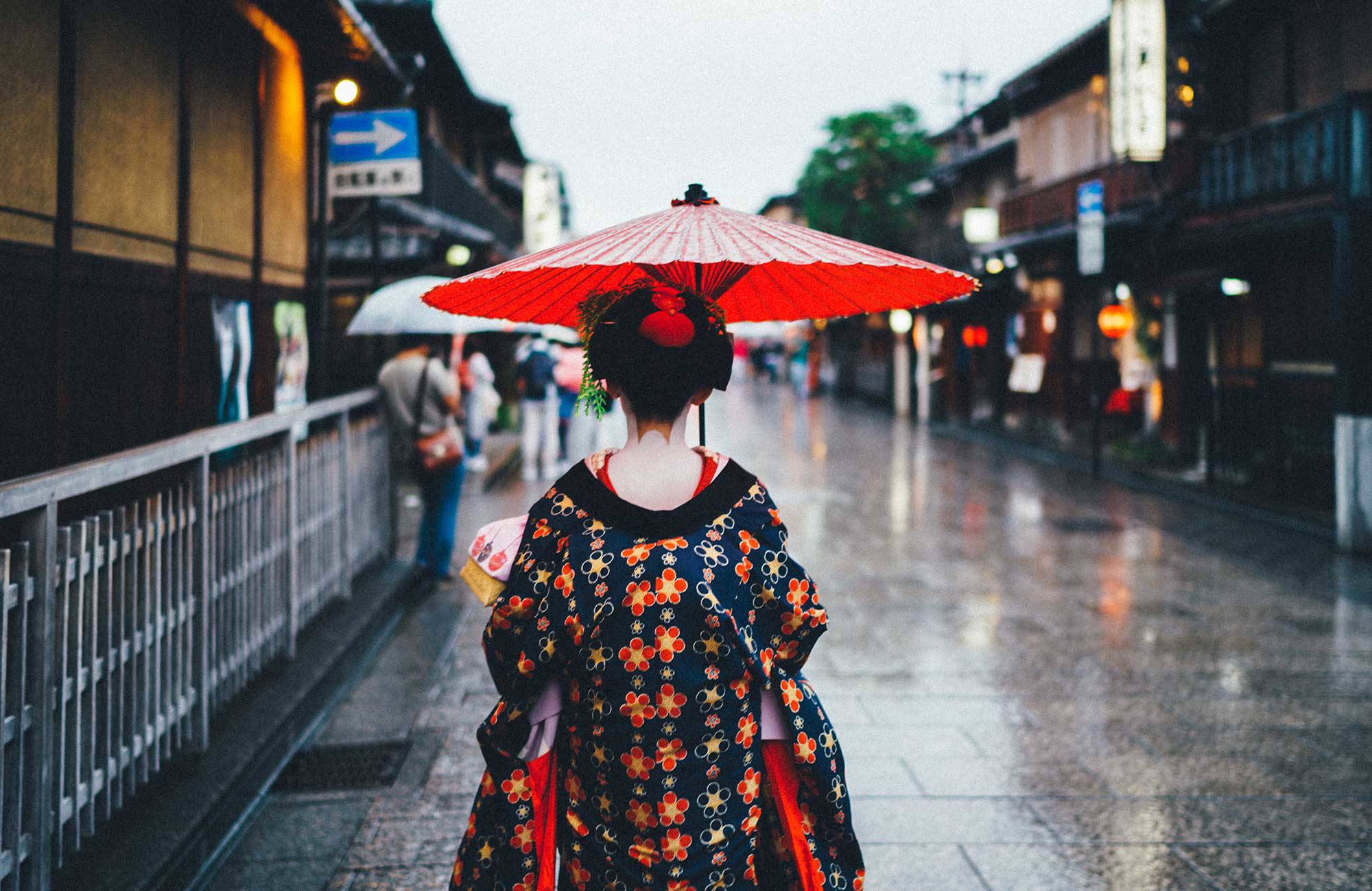 Kvinna med traditionella kläder på en gata i Kyoto