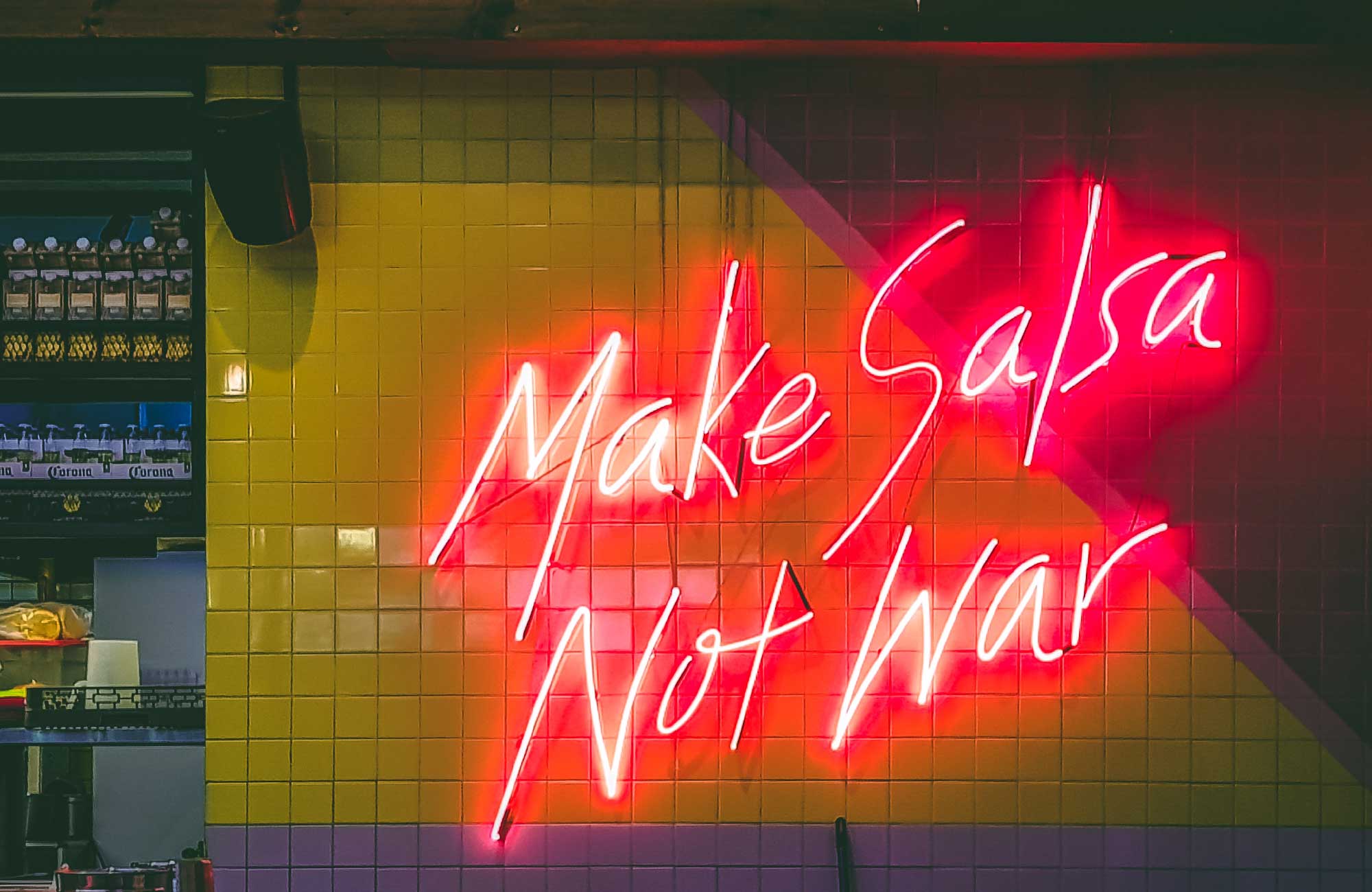 neonskylt i mexiko med texten make salsa not war