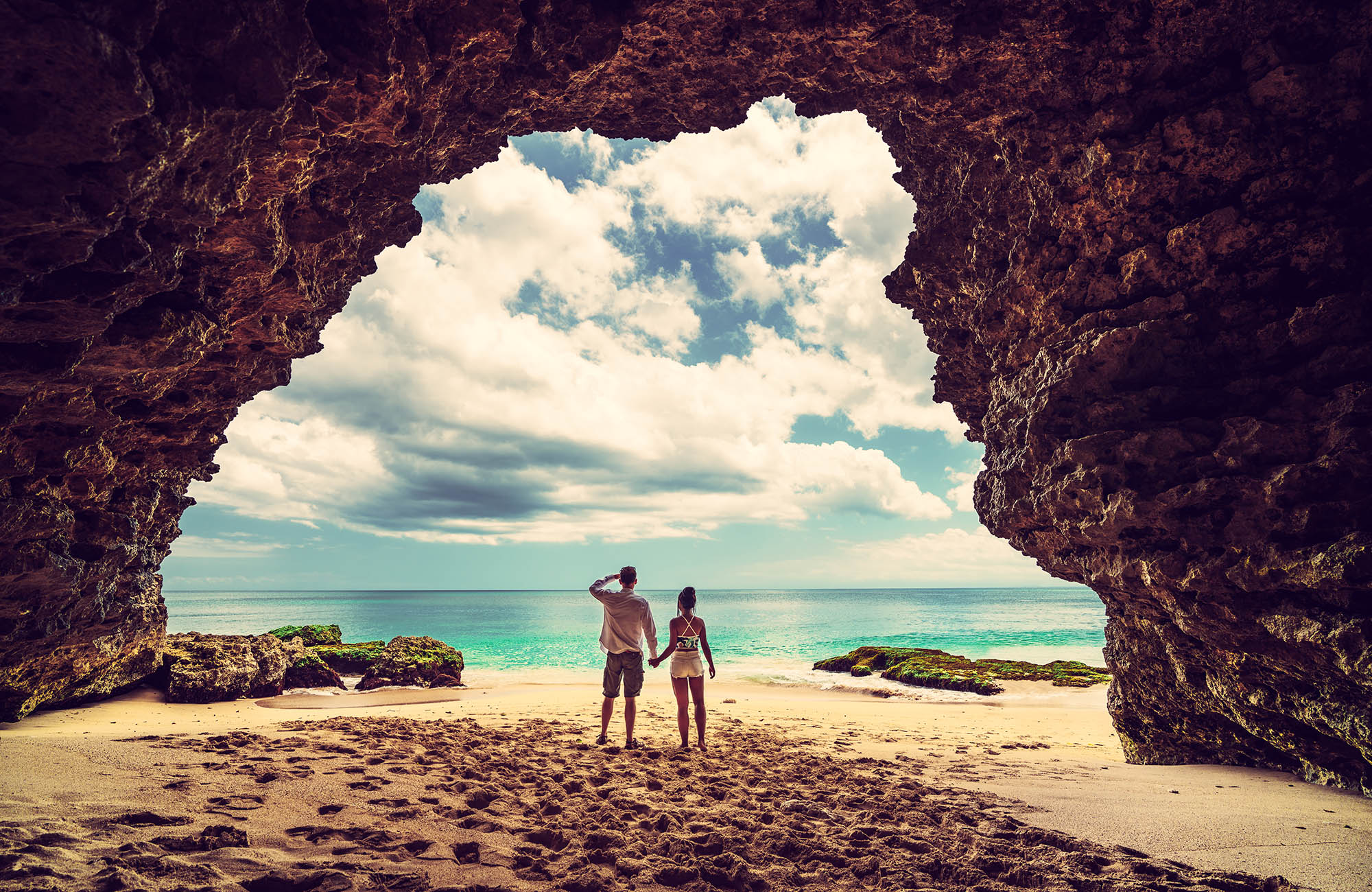 kvinna och man i en grotta på en strand på bali
