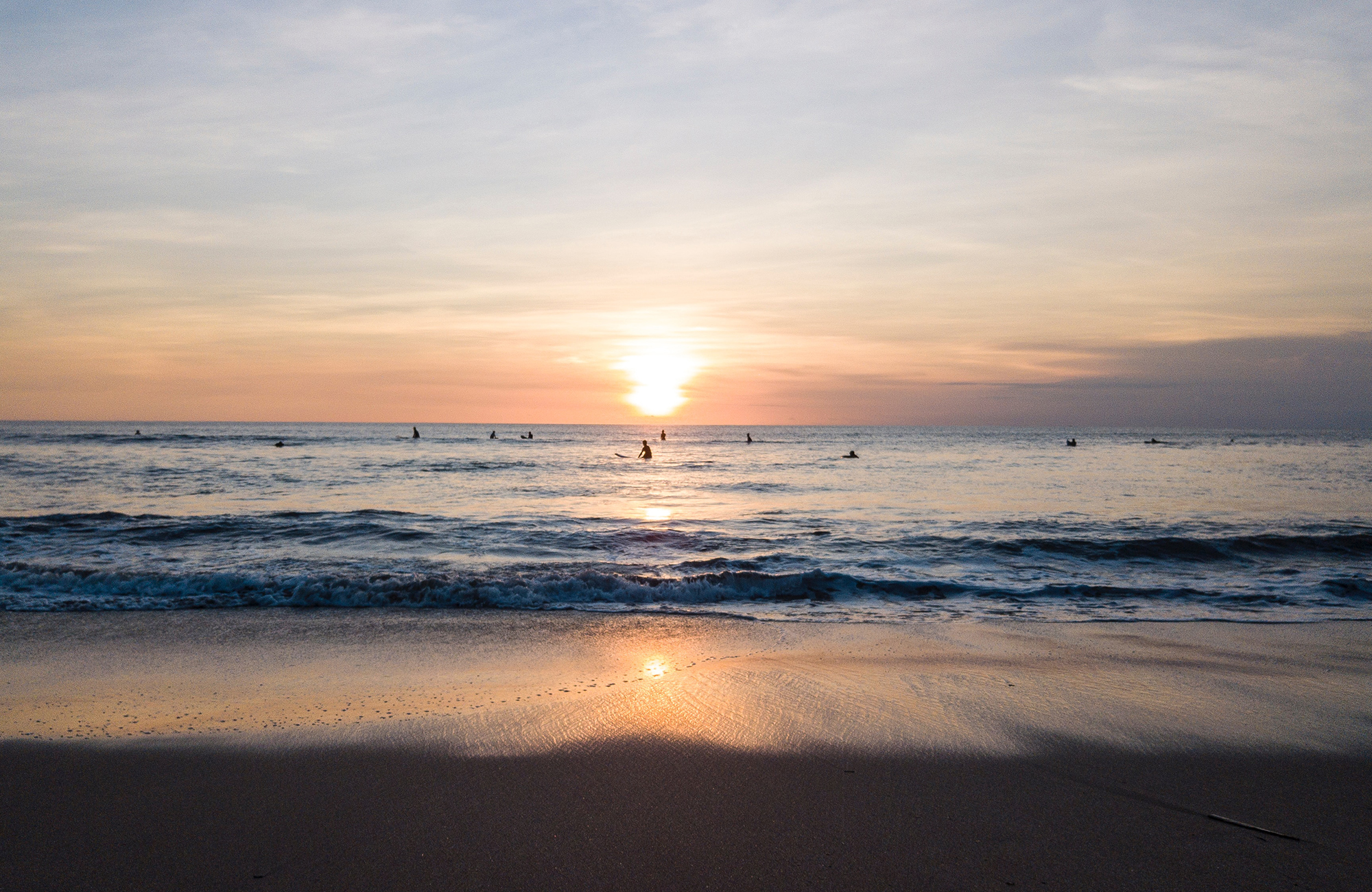 människor surfar utanför kuta beach på bali