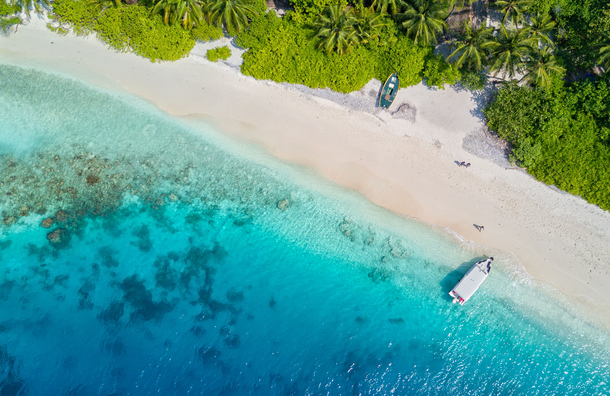 En liten båt på turkost vatten i Maldiverna.