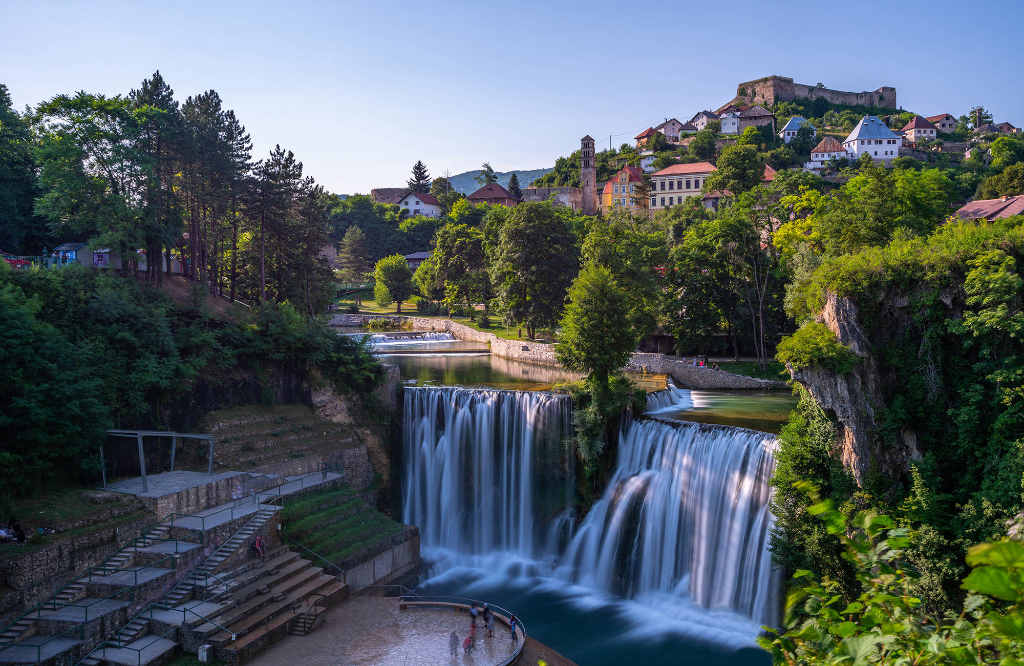 vattenfall i byn jajce med hus som växer på ett berg i Bosnien-Hercegovina