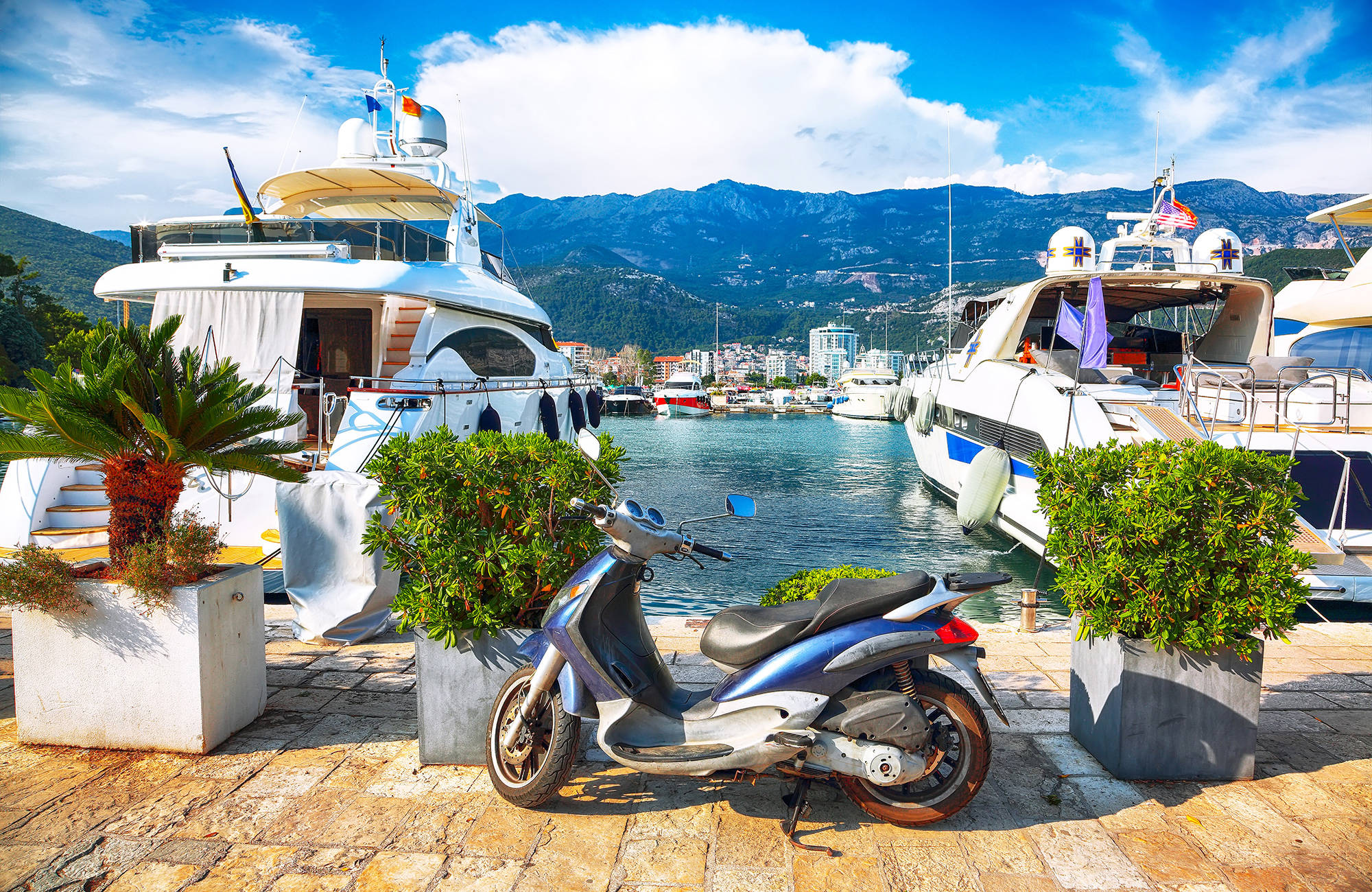dyra båtar och en moped i hamnen i budva