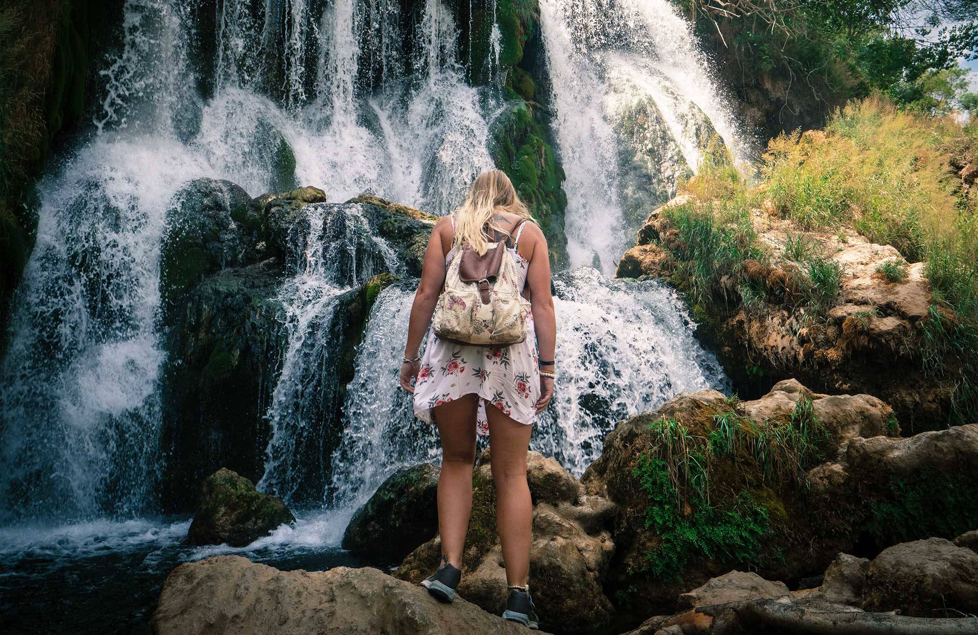 tjej står framför vattenfallet kravica i bosnien