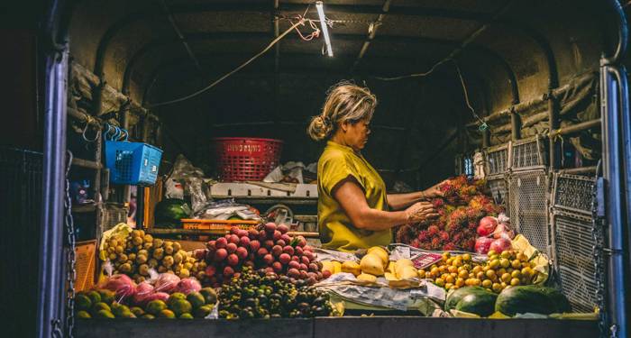 kvinna säjer frukt och grönt i thailand