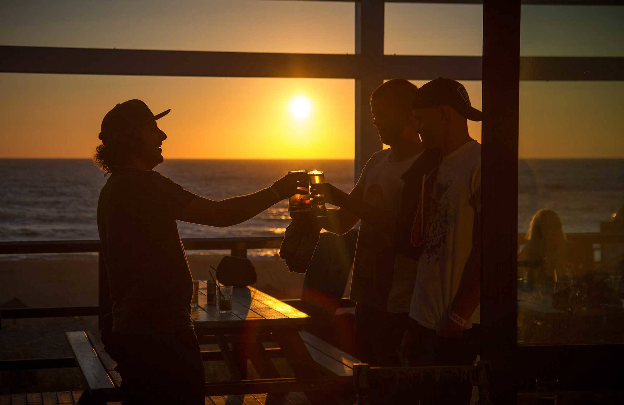 grupp skålar med öl i solnedgången under en rundresa i portugal