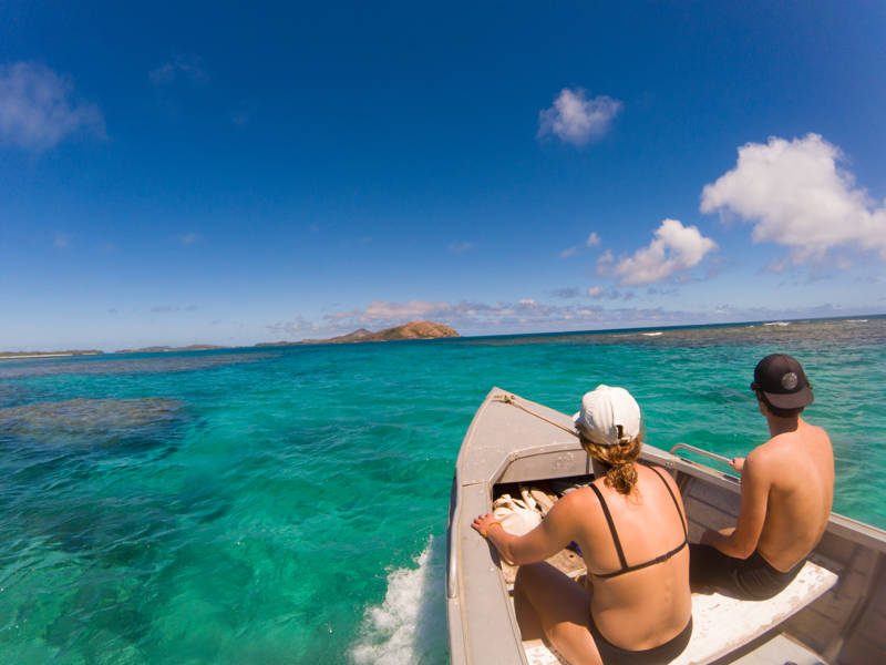 par som sitter på en båt i fiji på sin smekmånad