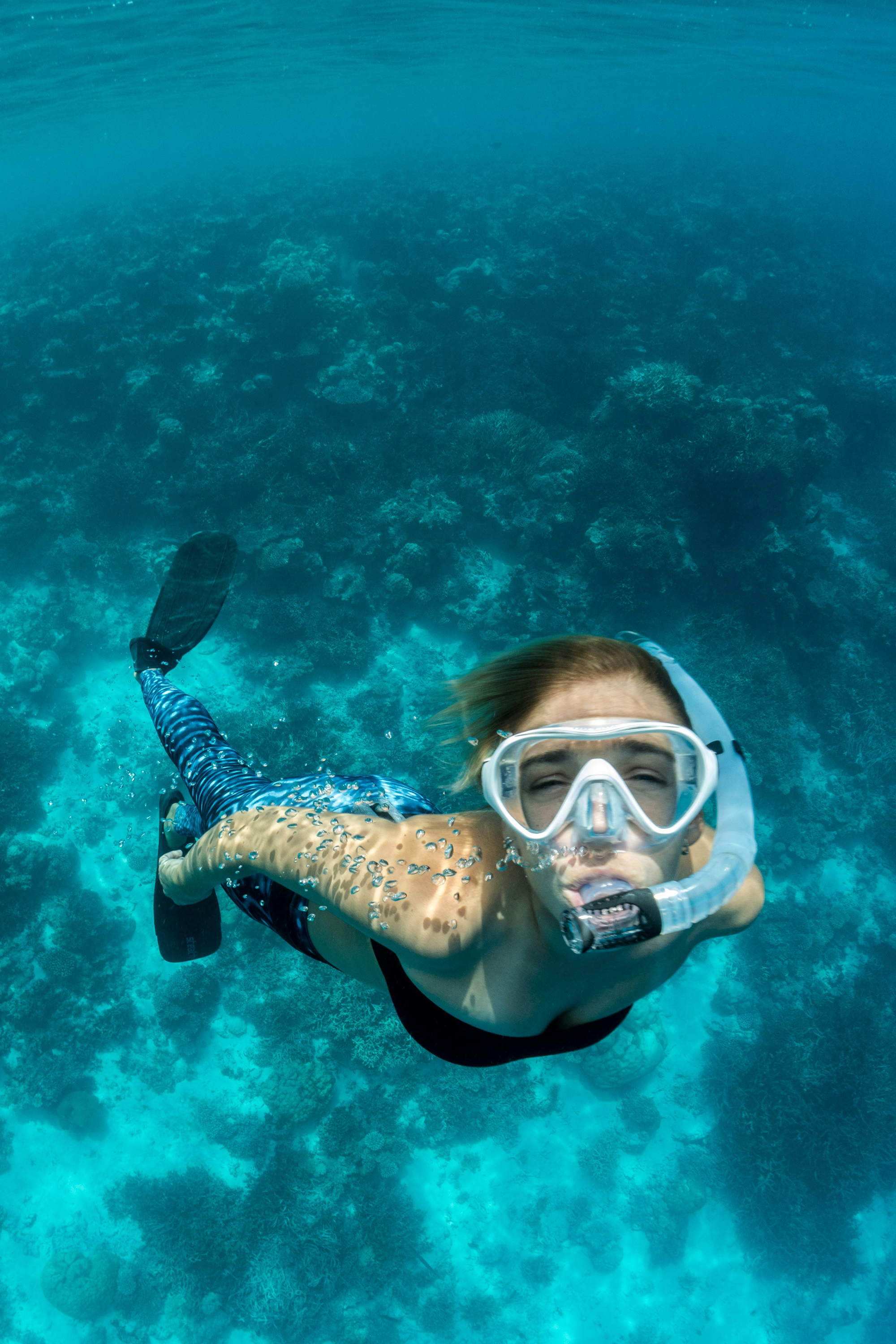 Meisje snorkelt bij de koraalriffen van de Malediven