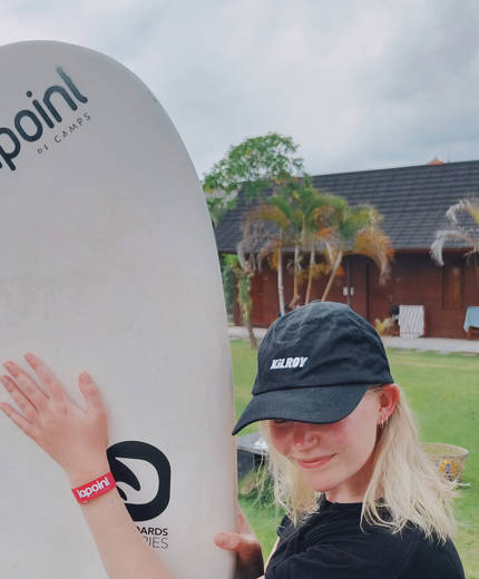 en kvinna på en strand under ett surfcamp i indonesien