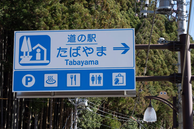 Blue and white road sign in Japan indicating the road side station of Tabayama