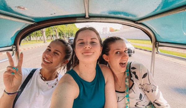Meisjes maken een selfie op een tuktuk in Bangkok