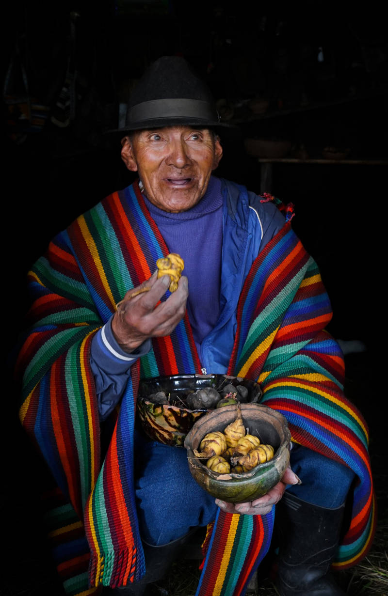 Man Dressed In Colours Offering Food In Latacunga, Ecuador