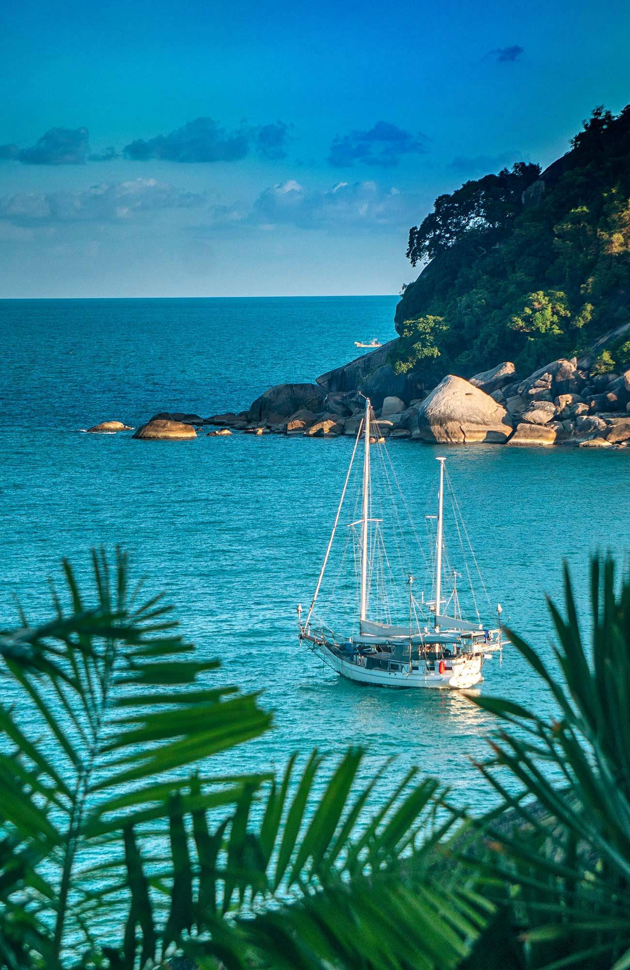 En seglbåt sedd från ovan med ett gäng som öluffar i Thailand.