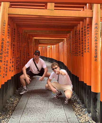 Bvå backpackers vid fushimi inari shrine på en resa genom Kyoto.